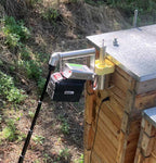 Telescopic support rod supporting an InstantVap beside a timber beehive